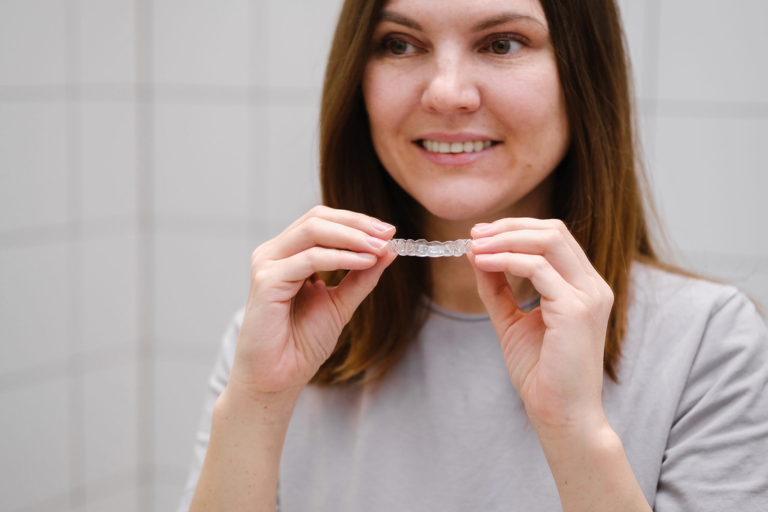 A woman with a set of at home teeth aligners