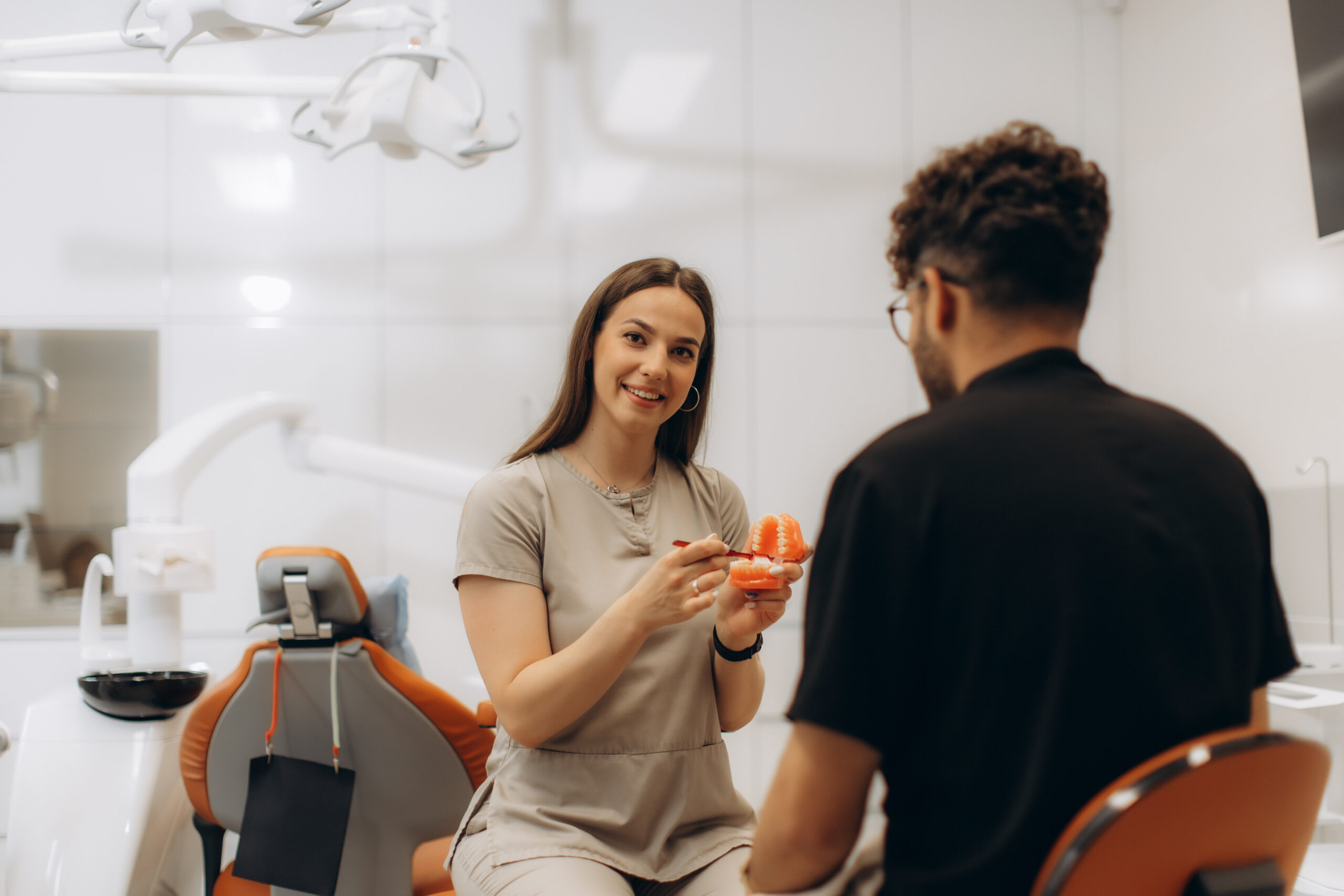 A female dentist explaining a dentist discount plan to a male patient.
