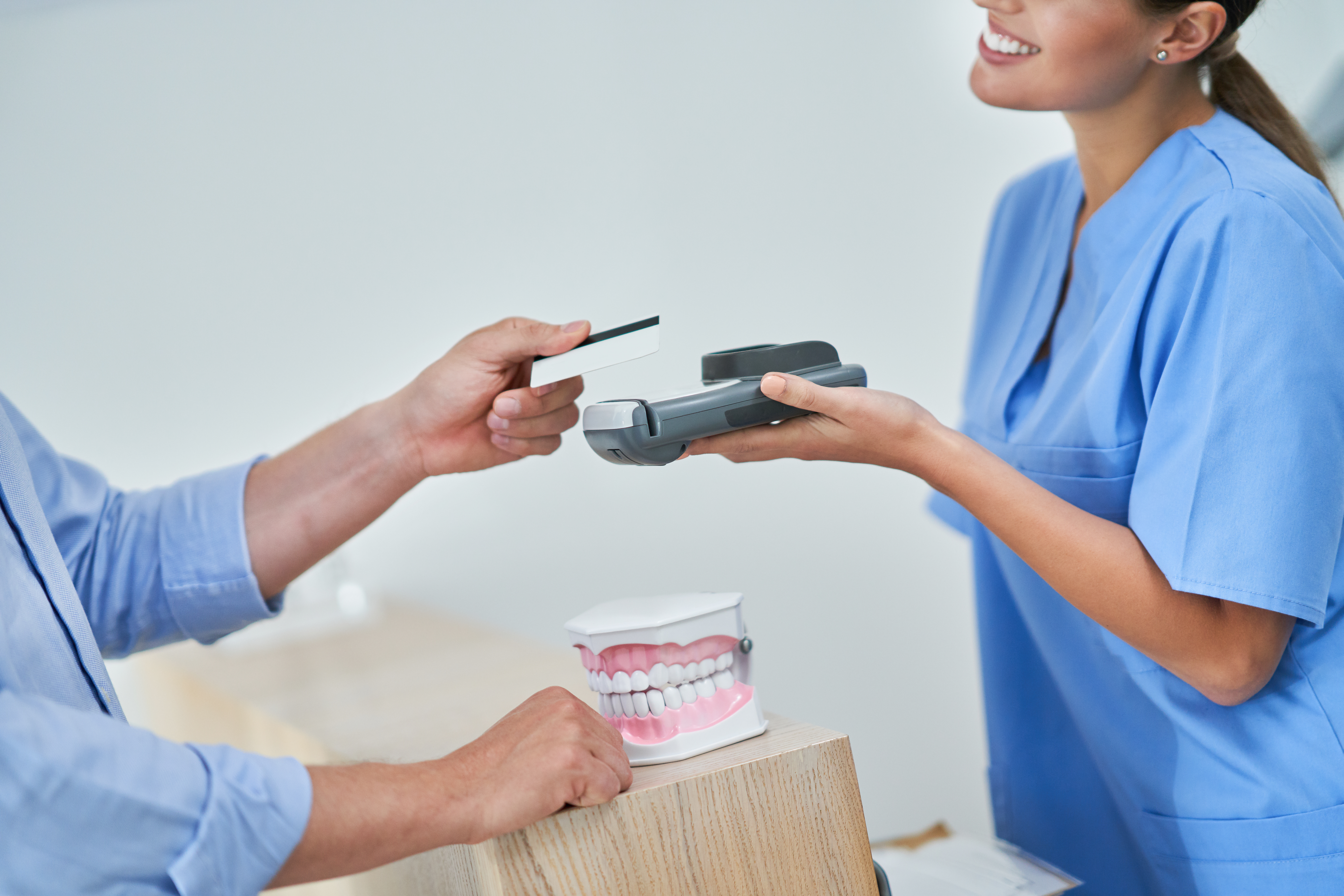 A male patient paying for the best dental discount plan in Florida.