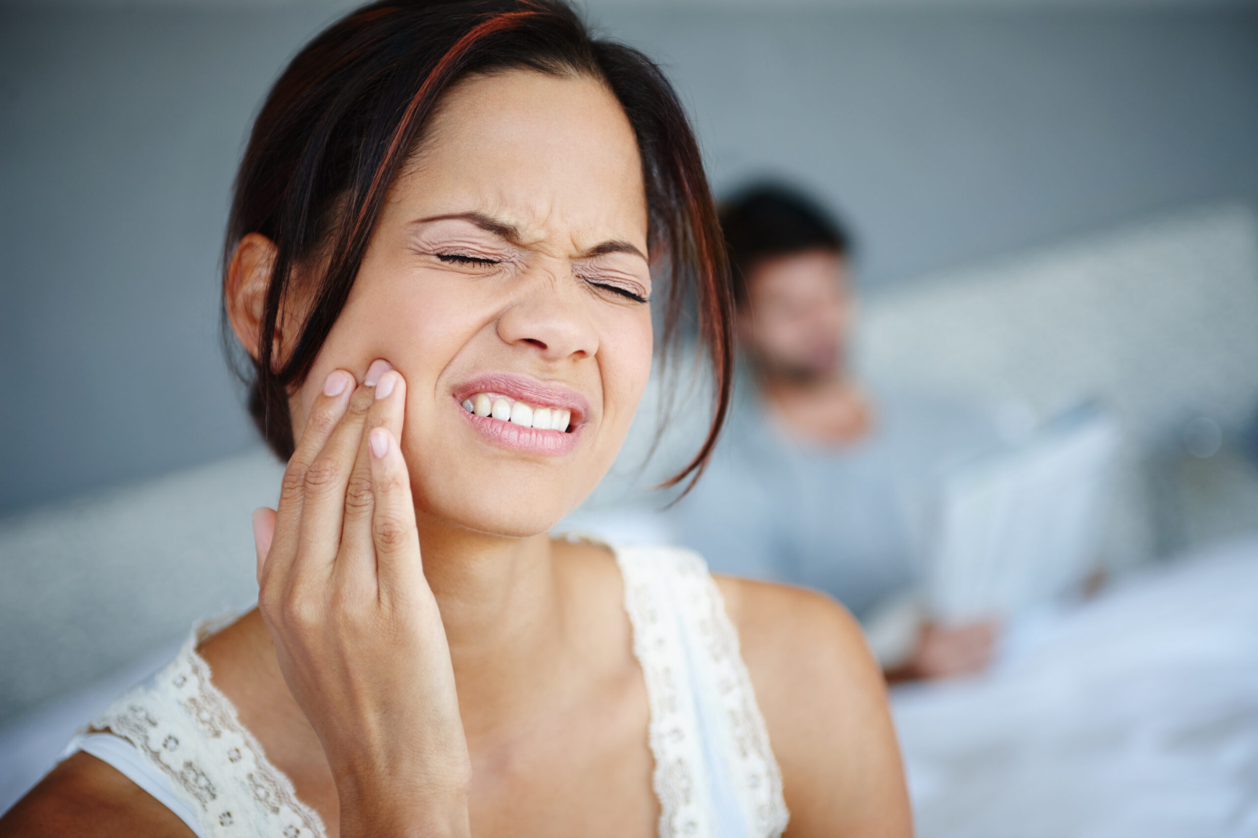A woman experiencing sudden tooth pain