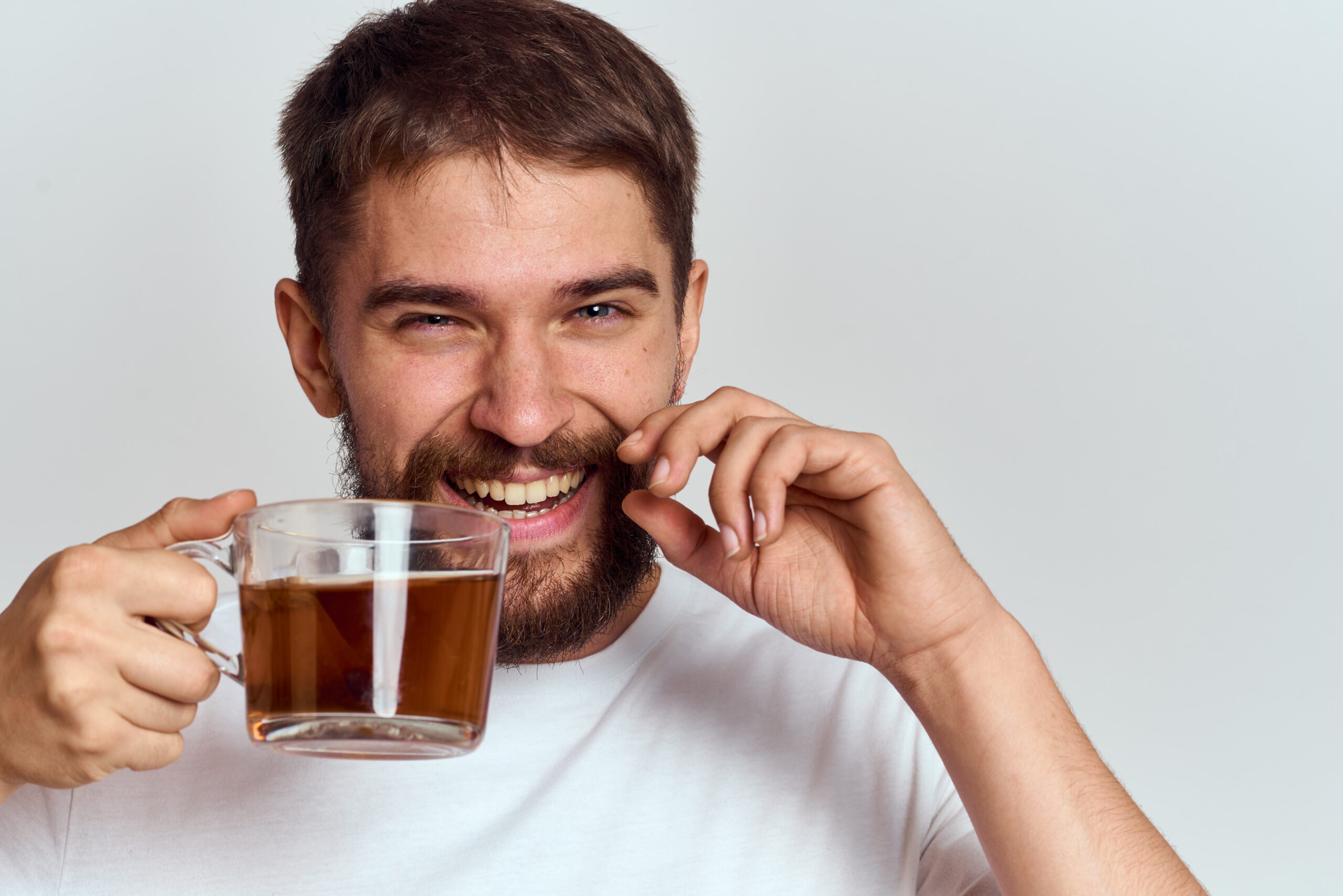 A man wondering, "does tea stain your teeth?"