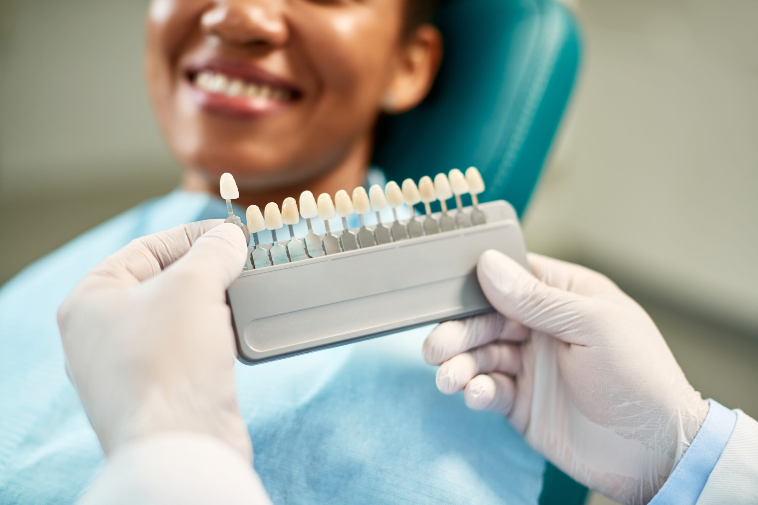 Denture colors being showing to a female dental patient.
