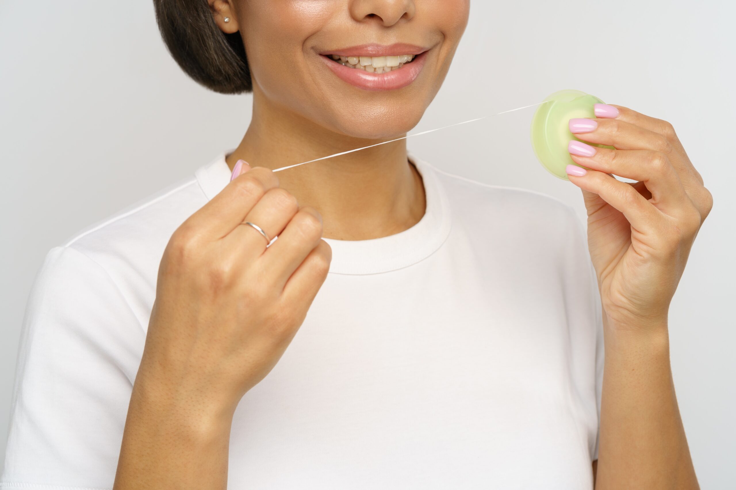 A woman wondering, "how many times a day should you floss?"