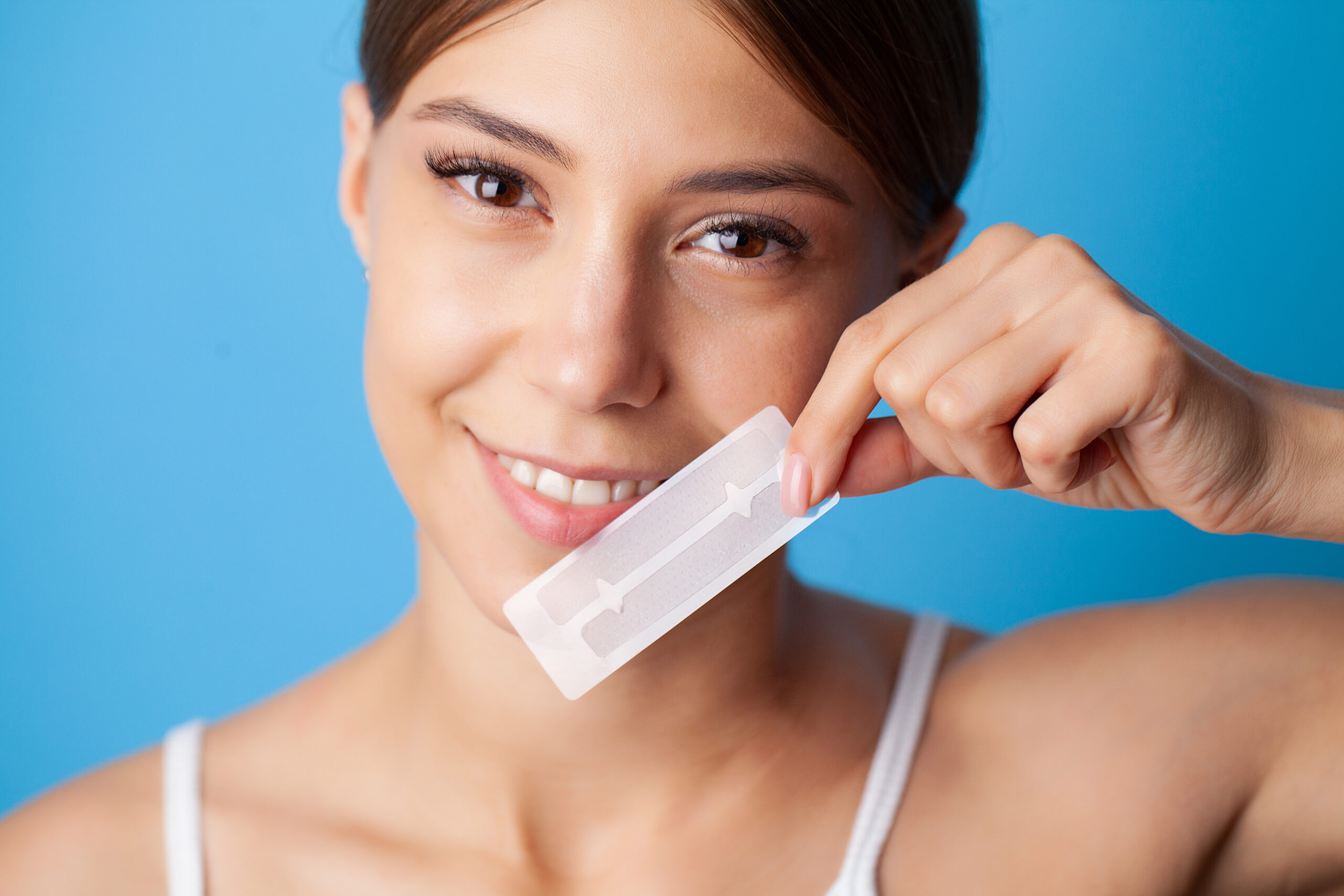A woman holding the best whitening strips.