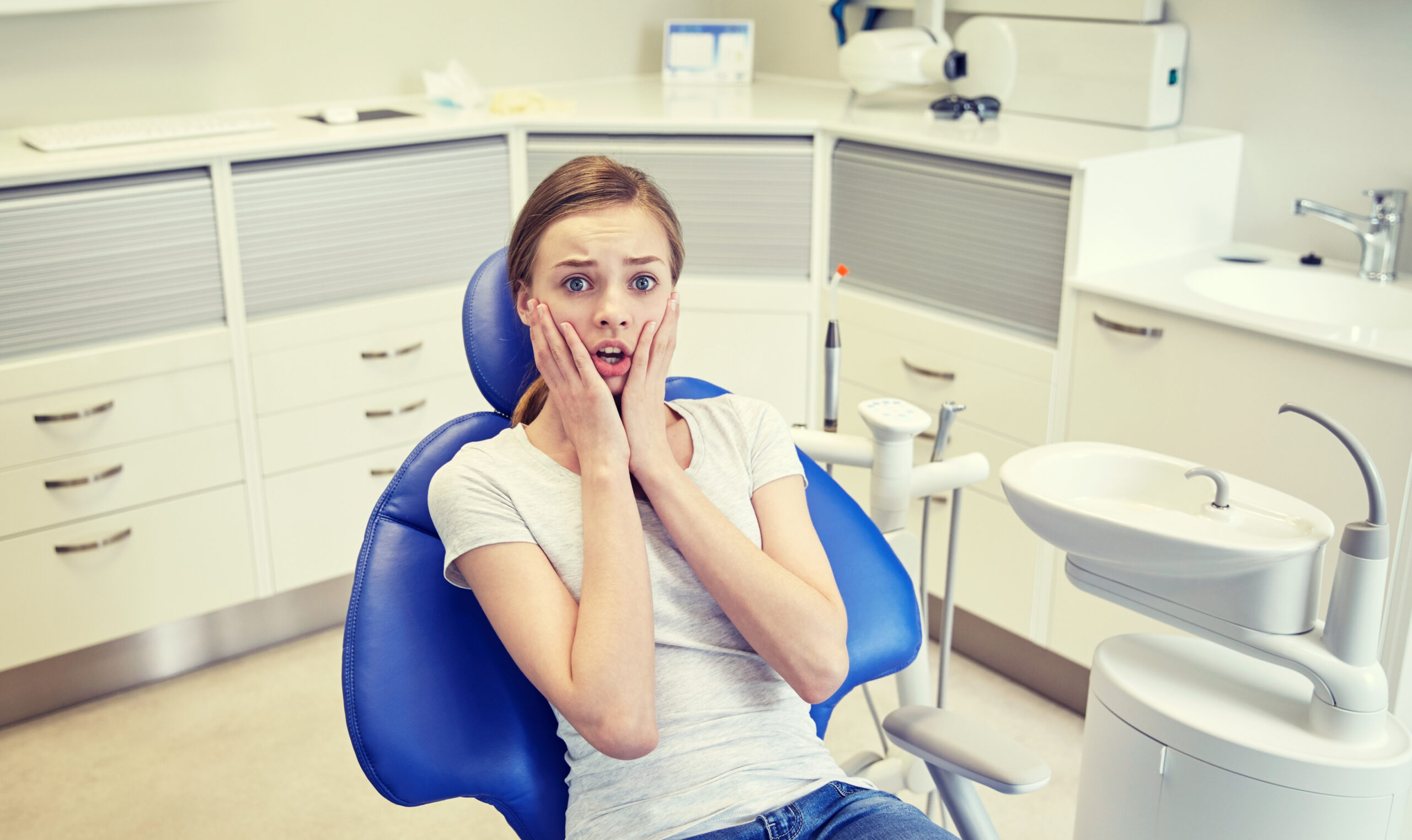 A concerned female patient wondering, "do I need dental insurance?"